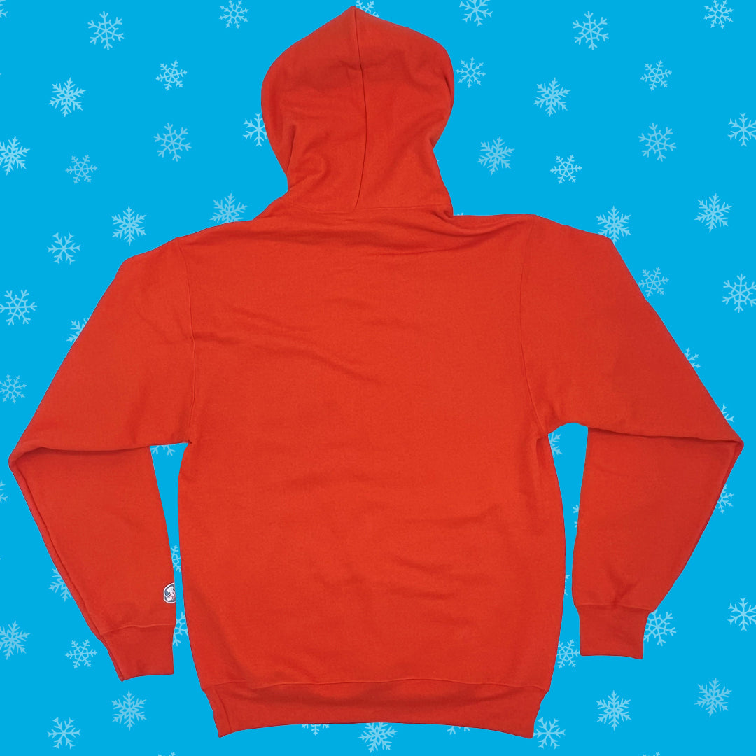 Rear view of an orange Drake’s Devil Dog Delight Hoodie against a blue background with white snowflakes. The hoodie is plain with a hood, visible seams, and a small Drake's logo on the left sleeve near the wrist. 